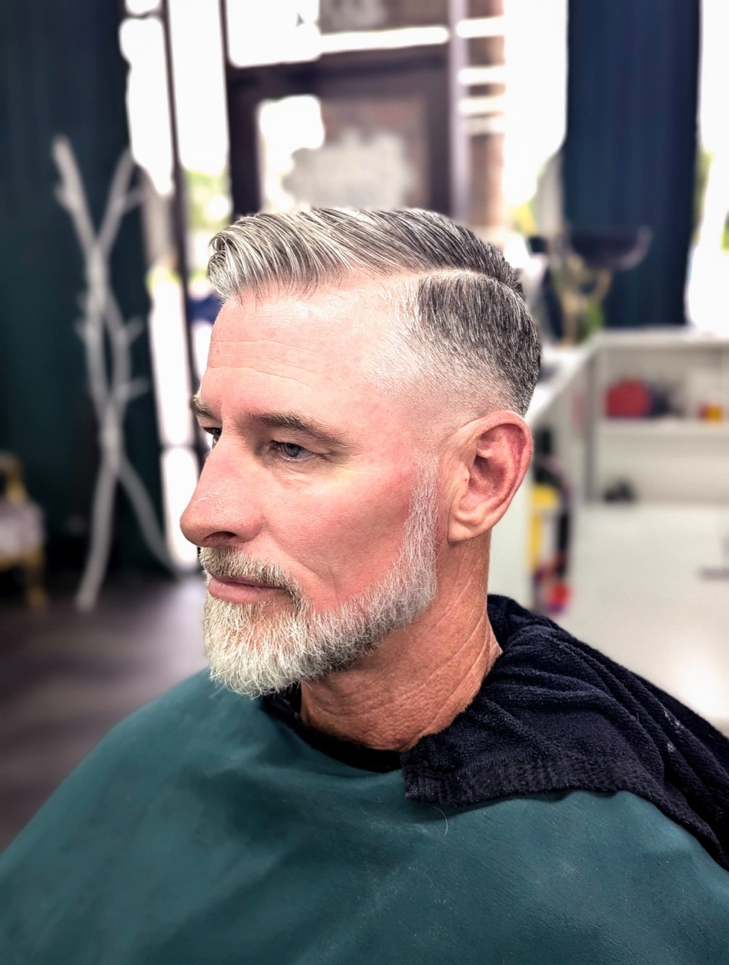 Side part with a tapered fade and groomed beard