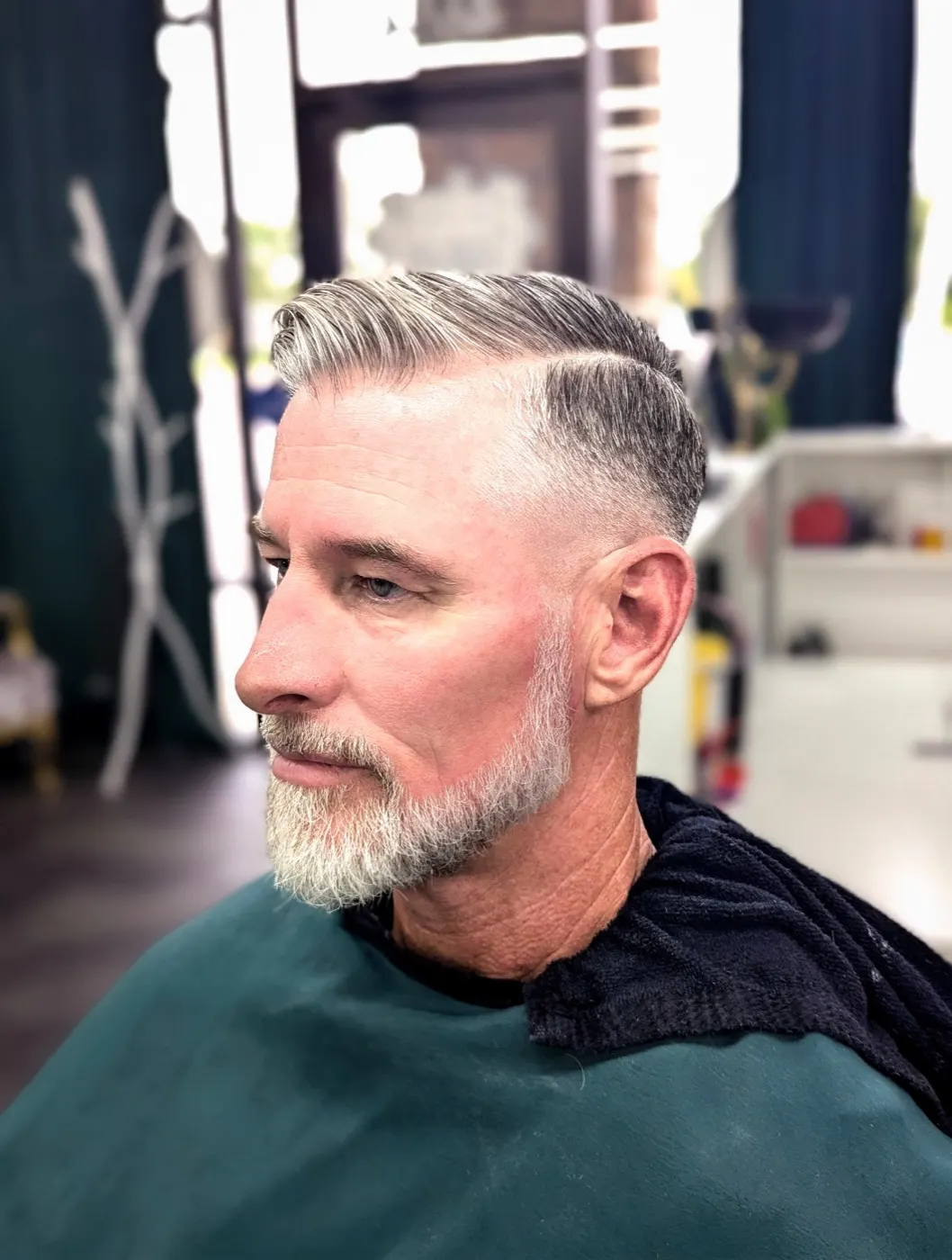 Side part with a tapered fade and groomed beard